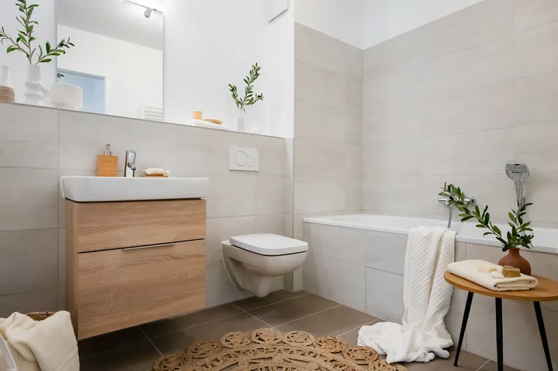 Helles Bad mit Badewanne, Waschtisch mit Holzunterschrank und wandhängendem WC