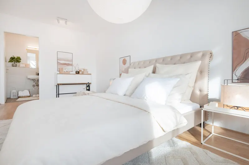 Schlafzimmer mit Doppelbett, Polsterkopfteil und Blick in den Flur