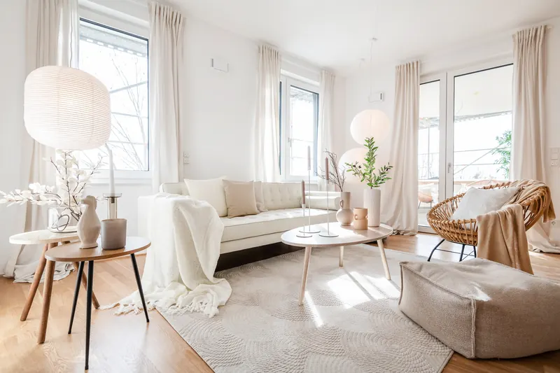 Wohnzimmer mit Sofa, Stehleuchte und Balkontür