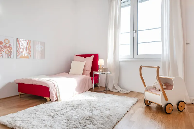 Kinder- oder Gästezimmer mit Tagesbett, Hochflorteppich und Holzspielzeug