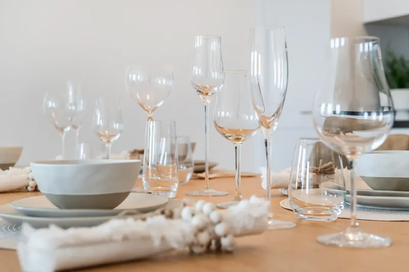 Gedeckter Tisch mit Weingläsern, Schalen und Servietten
